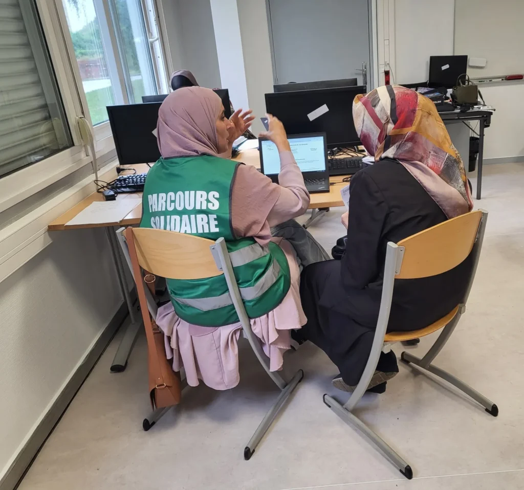 Personne qui aide une autre personne a utiliser un ordinateur